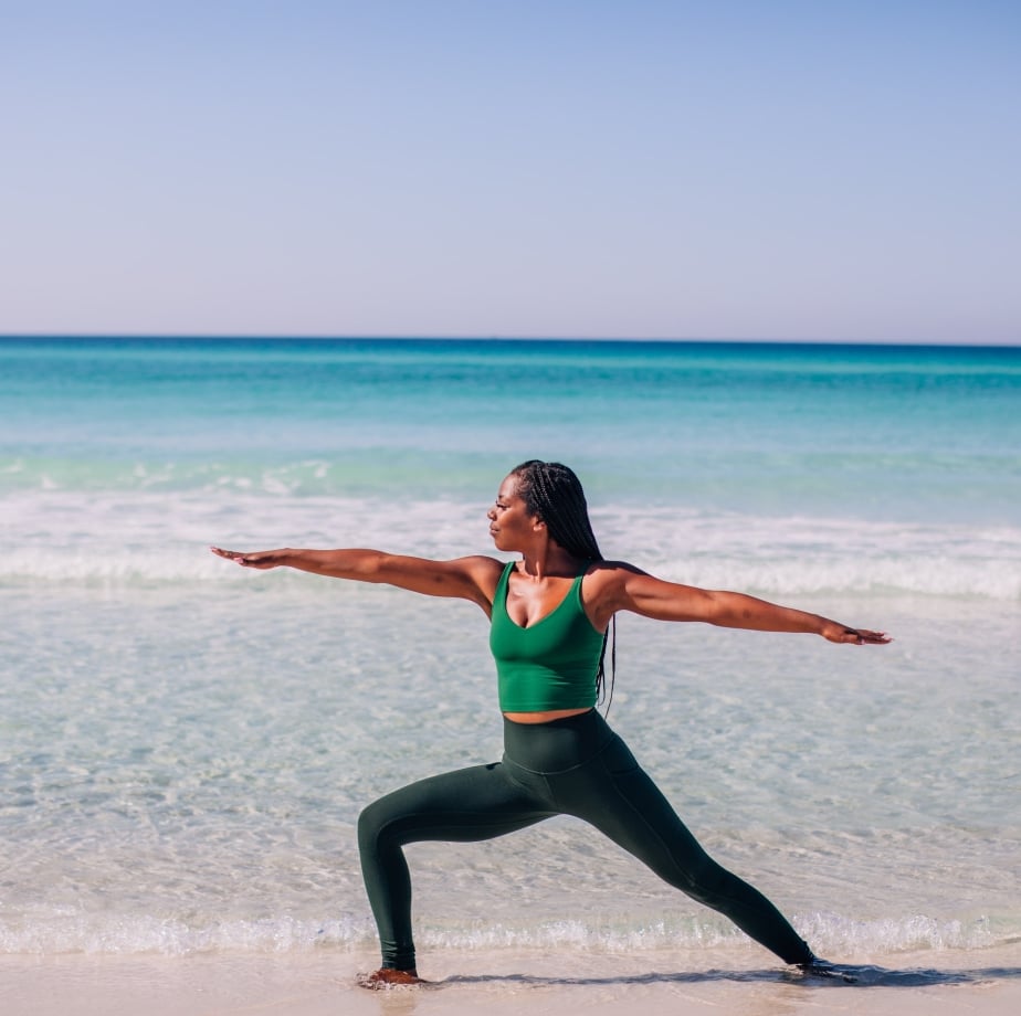 woman doing yoga pose on beach